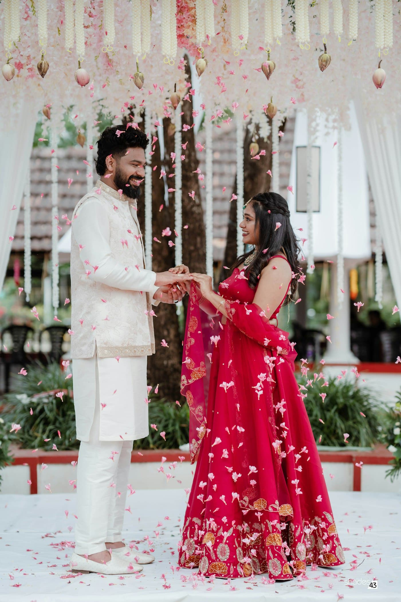 Couple standing beneath an ornate floral wedding canopy